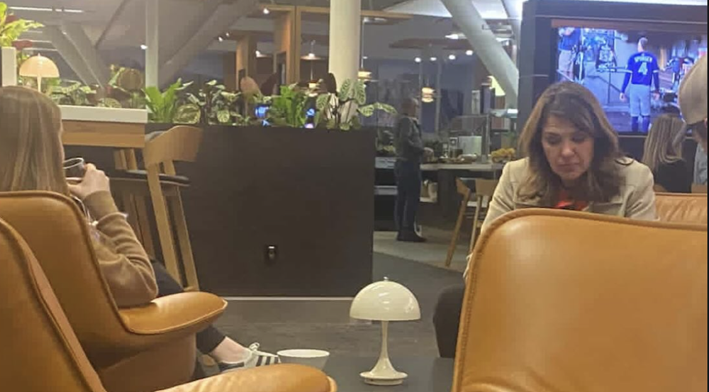 Alberta Premier Danielle Smith (right) was photographed sitting at the Calgary International Airport while UCP MLAs were still in the Legislature pushing through Bill 2 on Monday night. Smith is spending the week in Saudi Arabia and Dubai. (photo: publicinterestalberta / Instagram)